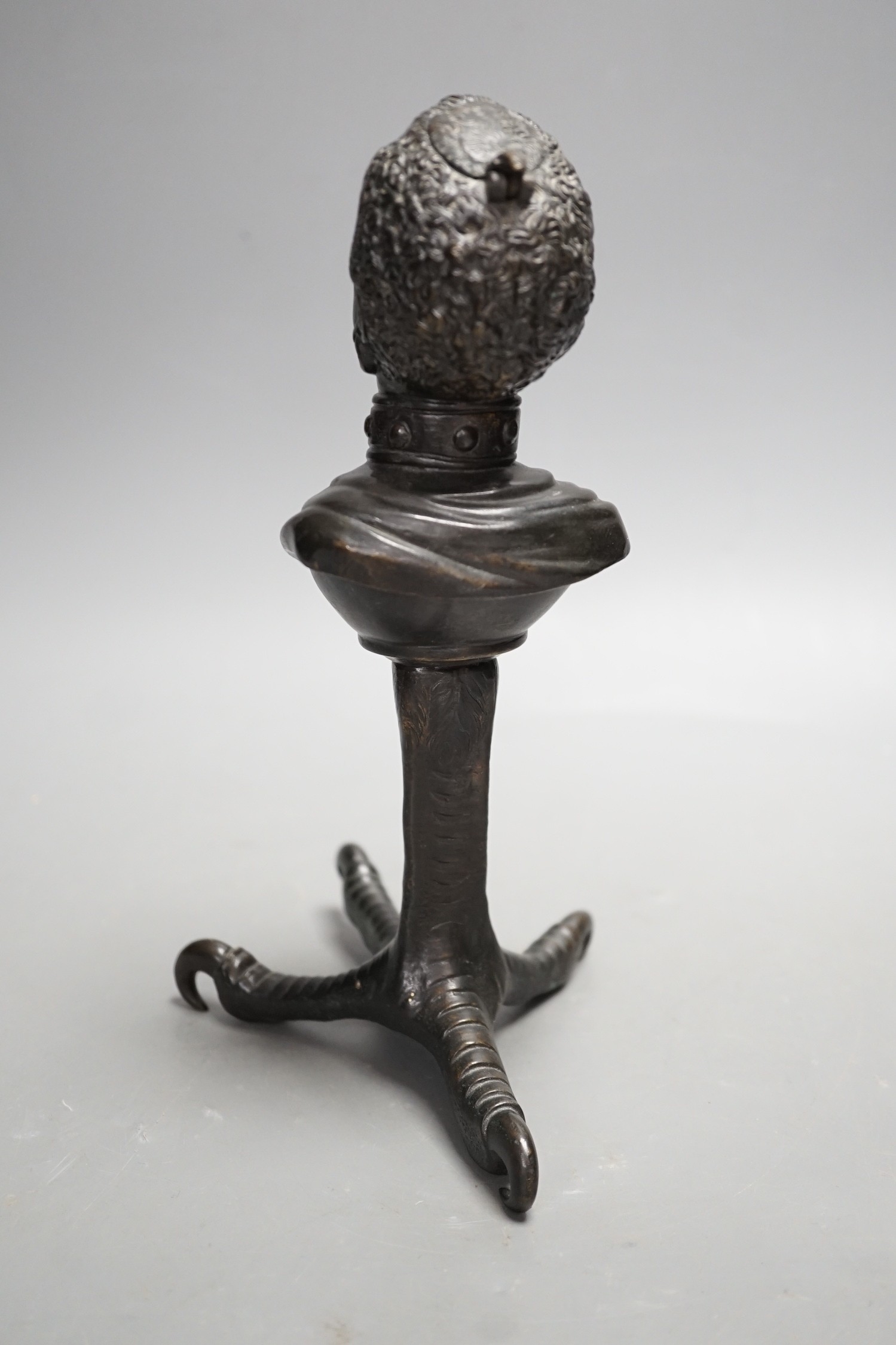 A bronze slave portrait bust on claw stand. 23cm high